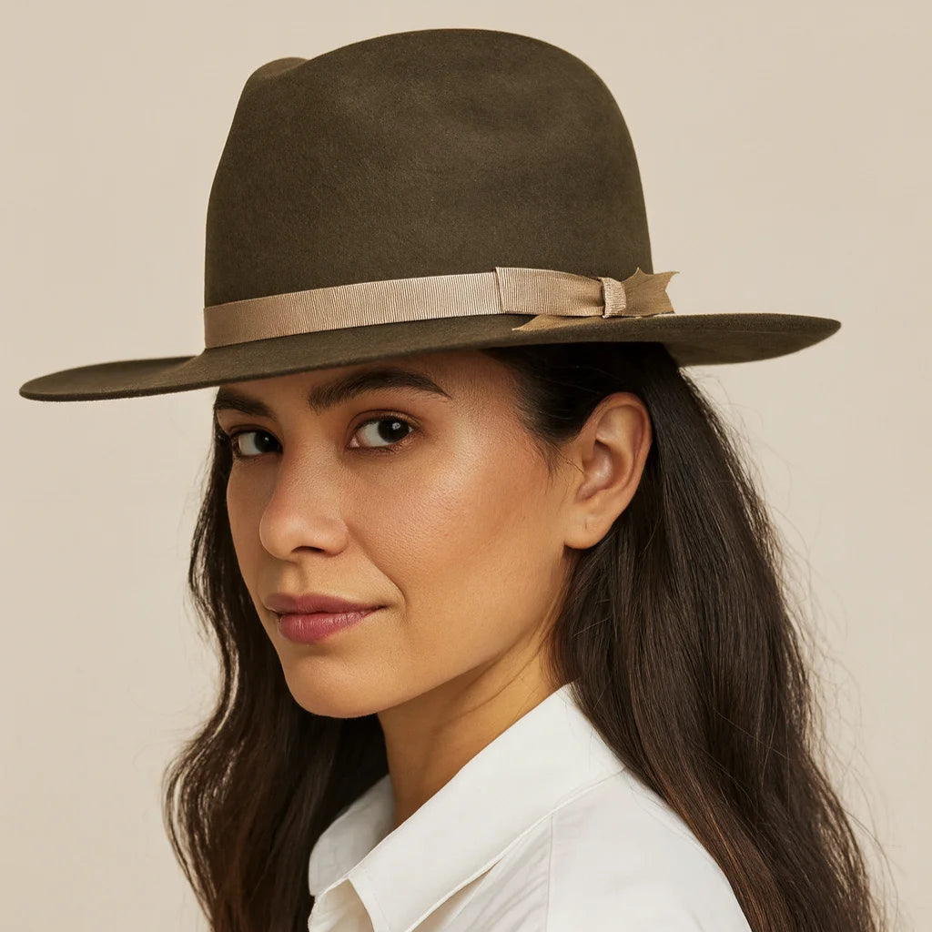 Woman wearing a brown hat with a gold band against a beige background